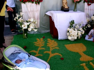 Altares con alfombras, flores y niños recién nacidos que reciben la bendición